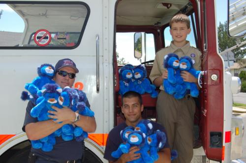 Michael and firefighters holding Ryan's Lions